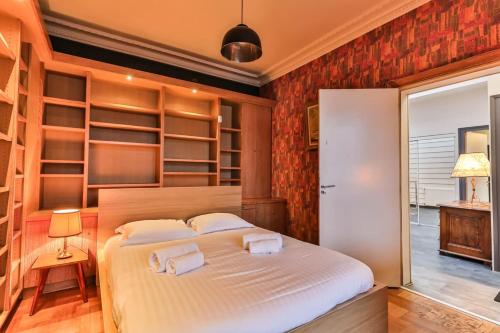 a bedroom with a large white bed with shelves at L'atypique - Piscine intérieure - Wifi in Challans