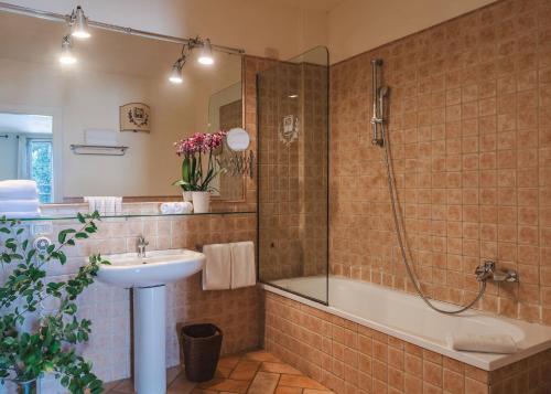 a bathroom with a tub and a sink and a shower at Borgo degli Ulivi - Castello di Montegridolfo in Montegridolfo