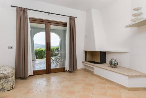 a living room with a fireplace and sliding glass doors at Villa Lu Nibaru 2 in Cannigione