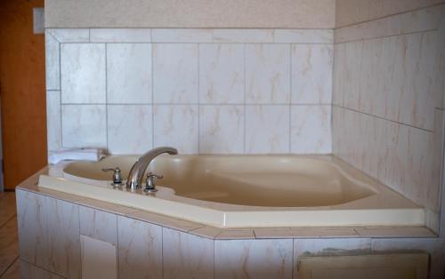 a bath tub with a sink in a bathroom at Ocean 1 Hotel & Suites Ocean City in Ocean City