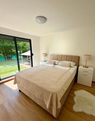 ein Schlafzimmer mit einem großen Bett und einem großen Fenster in der Unterkunft Aquaverde in Orašac
