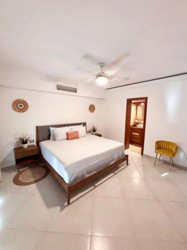 a large bedroom with a bed and a chair at Aligio Beachfront Paradise in Las Terrenas