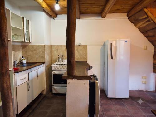 a kitchen with a white refrigerator and a stove at Finistterra in Tanti