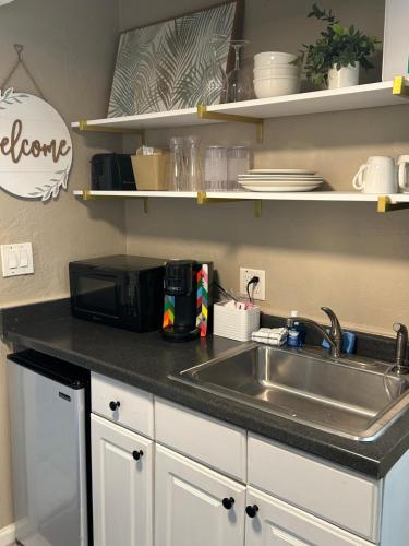 a kitchen counter with a sink and a microwave at Luxury Beach Condos with Pool and Tiki Bar! in Daytona Beach