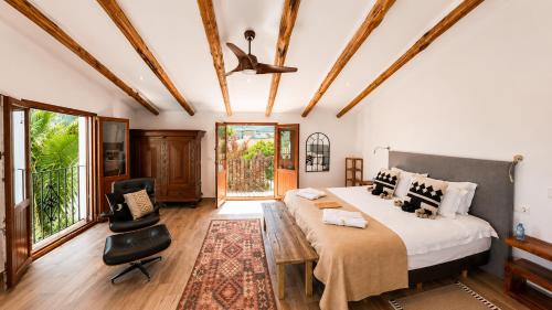 a bedroom with a large bed and a chair at Lemon Tree Retreat at El Amparo in Alhama de Granada