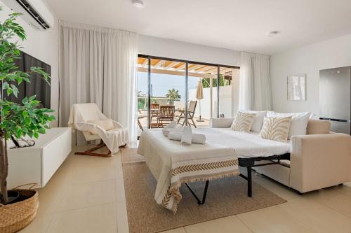 a white bedroom with a large bed and a couch at Oroklini Hills Modern Sea View Apartments in Oroklini