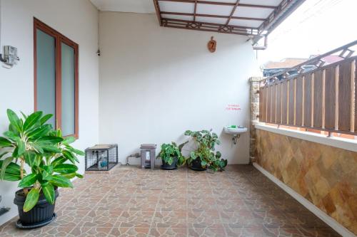 a room with potted plants and a balcony at RedDoorz at Syariah House Purwokerto in Purwokerto