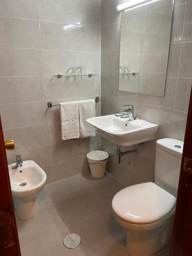 ein Badezimmer mit weißer Toilette und Waschbecken in der Unterkunft Hotel Almendra in Ferrol