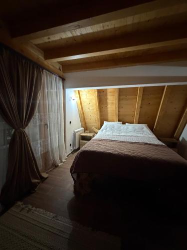 a bedroom with a bed in a room with wooden ceilings at Etno selo Vukovic Bijelo Polje in Bijelo Polje