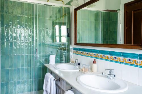 a bathroom with two sinks and a mirror at Molino Del Santo in Benaoján