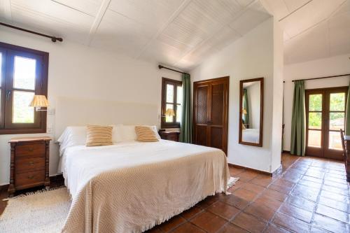 a bedroom with a white bed and a mirror at Molino Del Santo in Benaoján