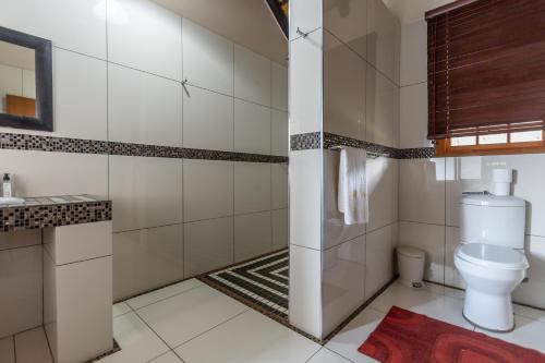 a bathroom with a toilet and a sink at Ndumu Safari Resorts in Ingwavuma