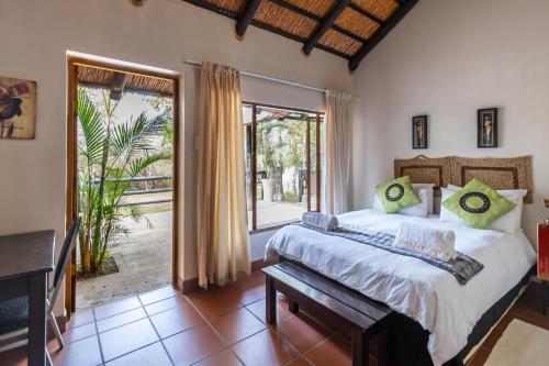 a bedroom with a bed and a large window at Ndumu Safari Resorts in Ingwavuma