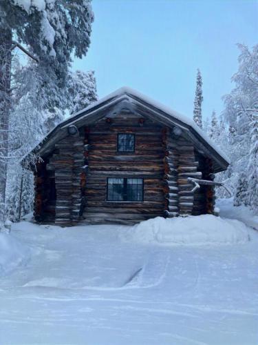 a log cabin in the snow with snow at Villa Pukelo Arctic Lodge with wifi sauna 4 poster bed fireplace in Salla