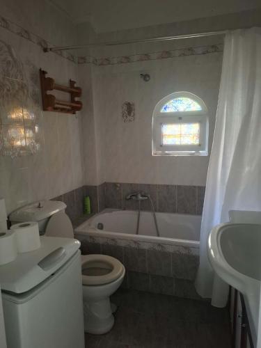 a bathroom with a toilet and a tub and a sink at Διαμερισμα επάνω στο κυμα in Kineta