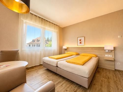 ein Schlafzimmer mit zwei Betten und einem Fenster in der Unterkunft Hotel-Heilsberg in Gottmadingen