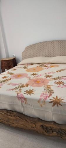 a bed with a comforter with flowers on it at La Dormeuse in Vignacastrisi