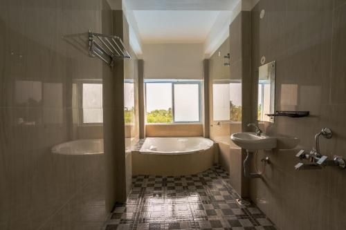 a large bathroom with a tub and a sink at Sunlux Villa in Pondicherry