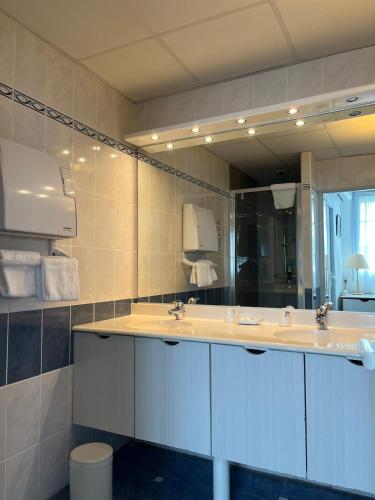 a bathroom with two sinks and a large mirror at Hotel De La Mer in La Tranche-sur-Mer