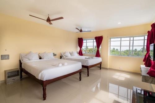 two beds in a room with red curtains at Sunlux Villa in Pondicherry