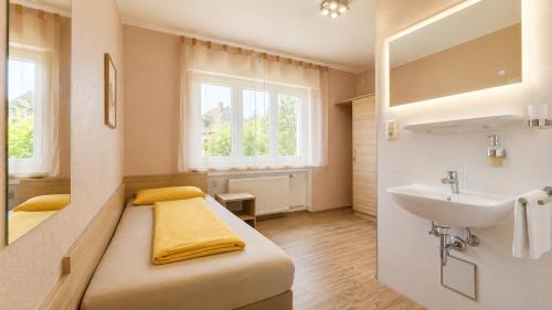 ein kleines Badezimmer mit Bett und Waschbecken in der Unterkunft Hotel-Heilsberg in Gottmadingen