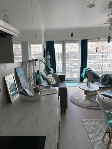 a living room with a couch and a table at Ma Mère Beach Condo Oostende in Ostend