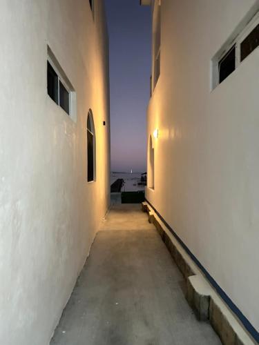 an alleyway between two buildings with the ocean in the background at Departamentos Blue Bacalar in Bacalar