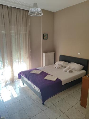 a bedroom with a large bed with a purple blanket at Hotel La Strada in Tycherón