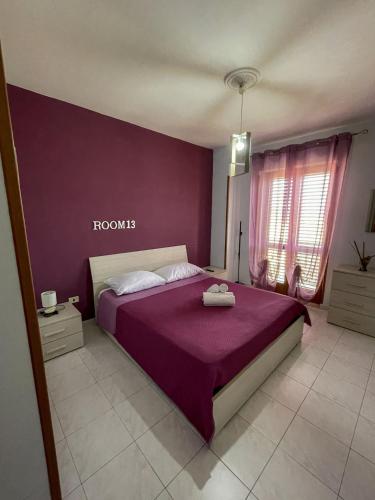 a bedroom with a bed with a purple wall at La Piazzetta in Torella deʼ Lombardi