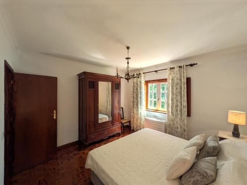 a bedroom with a bed and a dresser and a window at Casa da Sofia in Ponte da Barca