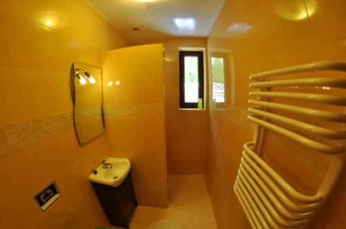 a yellow bathroom with a sink and a toilet at Willa Kalinowa in Sopot
