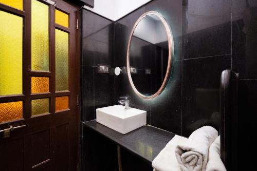 a black bathroom with a sink and a mirror at Guesthouse Tofu- Fort View in Jaisalmer