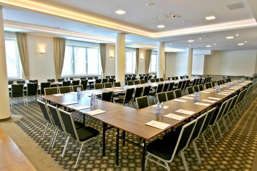 a large conference room with long tables and chairs at Hotel Nowy Zdrój - Centrum Zdrowia i Wypoczynku in Polanica-Zdrój