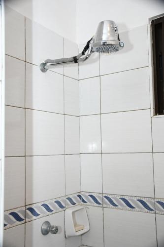 a white tiled bathroom with a light on the wall at Caramel Home in Mombasa