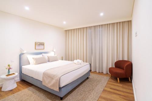 a bedroom with a bed and a chair at Casa Amarela do Redondo in Seixal
