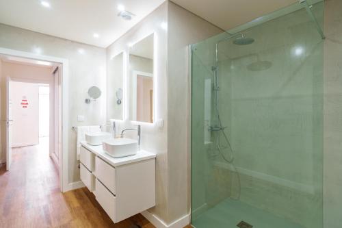 a bathroom with two sinks and a glass shower at Casa Amarela do Redondo in Seixal