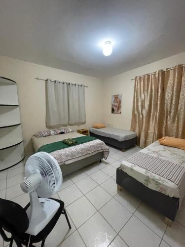 a room with three beds and a fan in it at Apartamento em Seabra in Seabra