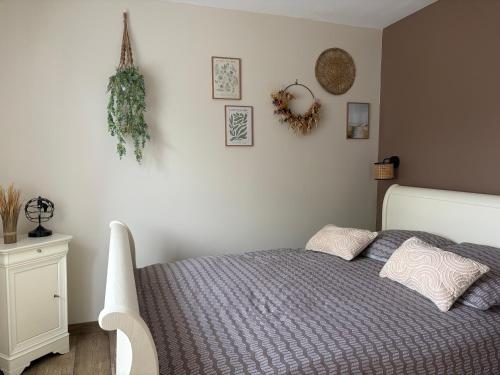 a bedroom with a bed and some pictures on the wall at Au Souffle Marin Maison 2 chambres in Berck-sur-Mer