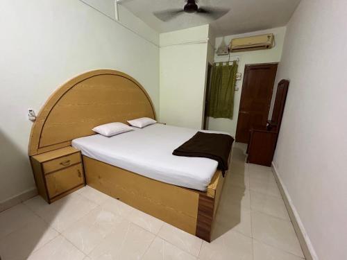 a bedroom with a bed with an arch shaped headboard at Cassa ff guesthouse in Palolem