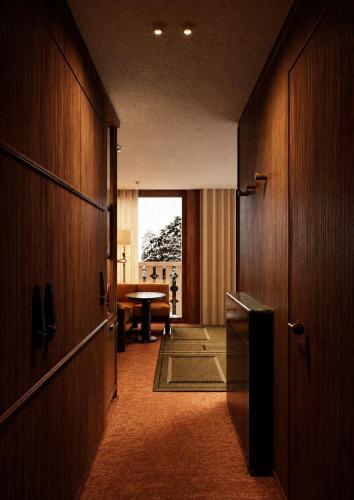 a hallway with a room with a table and a door at Bourbon Hôtel in Courchevel