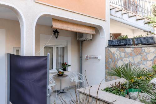 a patio in a house with a table and chairs at Apartments Jurić in Vrsar