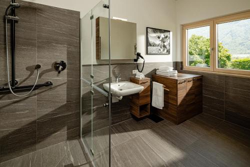 a bathroom with a sink and a glass shower at Rauchhof Apartments in Auer