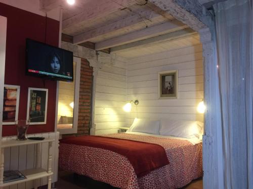 a bedroom with a bed and a tv on a wall at Apartamentos Alquitara in Potes