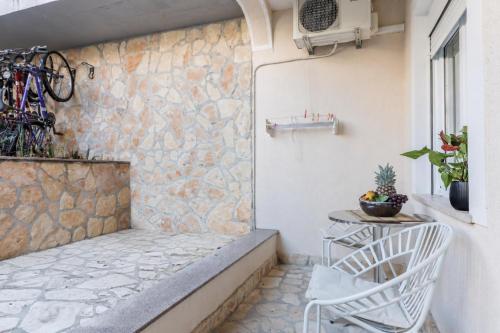 a patio with two chairs and a stone wall at Apartments Jurić in Vrsar