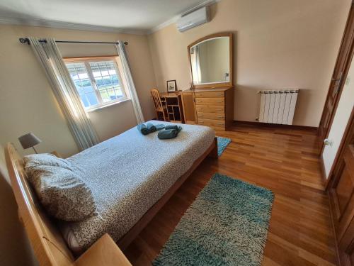 a bedroom with a bed with a mirror and a dresser at Toca dos Coelhos in Silveira