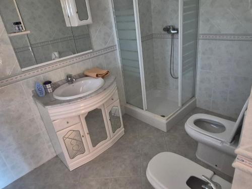 a bathroom with a sink and a shower and a toilet at Toca dos Coelhos in Silveira