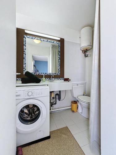 a bathroom with a washing machine and a sink at Studio Coin Du Bonheur in Saint-François