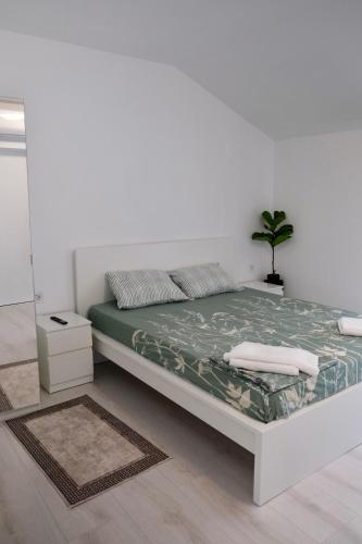 a white bedroom with a bed and a mirror at The View in Satu Nou de Sus