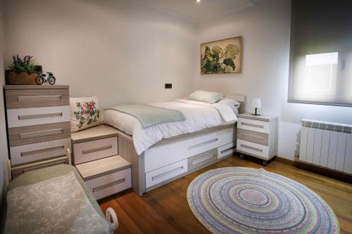 a bedroom with a bed and a dresser and a rug at Casa dos olivos in Ourense