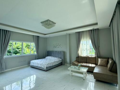 a living room with a bed and a couch at Paiyawadee House khaoyai in Ban Hua Phrong